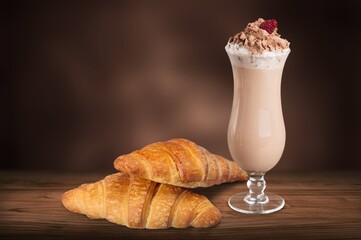 Freshly baked croissants, a cup of coffee on the desk