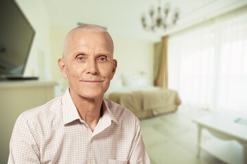 Portrait of beautiful smiling senior man posing at home room