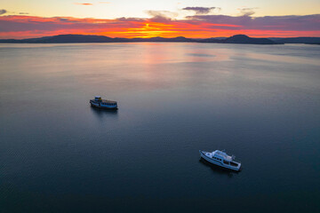 Pink and purple sunrise waterscape with boats
