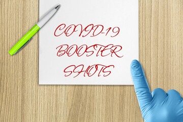 Covid-19 booster shots vaccine symbol. White note with metallic pen.
