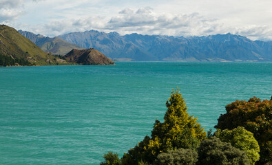Scenic landscape view of Lake Hawea in New Zealand showing turquoise water with mountains in the...