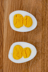 Sliced egg with two yolks on wooden background, 8 march holiday concept