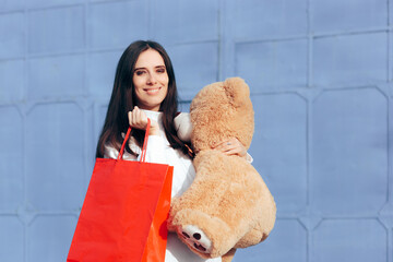 Happy Woman Holding a Big Teddy Bear Toy and a Shopping Bag