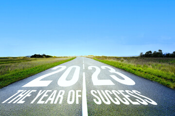 2023 written on the highway in the middle of an empty asphalt road and a beautiful blue sky. Vision...