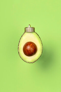 Christmas bauble decoration of avocado on green. New year concept.
