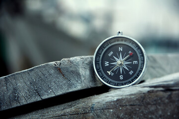 Close up of navigational compass on a pile of wood