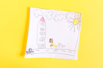 Children's drawing with colored pencils on a sheet of white paper bright yellow background