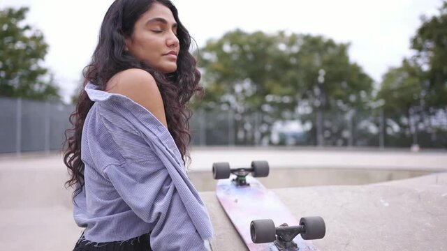Mixed race beautiful fit hispanic black millennial woman in New York city. skateboarder girl hipster at skatepark. Urban modern lifestyle, fashion in NYC, multi-ethnic race American.