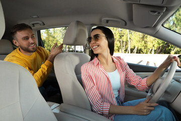 Young man talking with driver in modern car