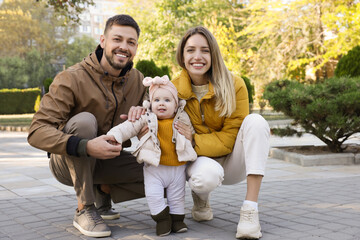 Fototapeta premium Happy parents with their baby in park on sunny day