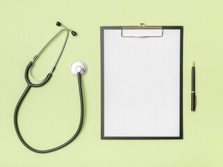 Doctor's desk top view. Stethoscope and notebook on a colored background