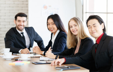 Positive multiethnic colleagues sitting in conference room
