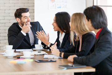 Positive multiethnic colleagues sitting in conference room