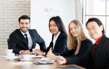 Positive multiethnic colleagues sitting in conference room