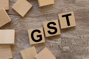 GST. text on wooden blocks on a wooden background
