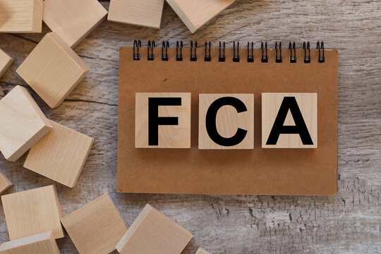 FCA. the text on the wooden blocks that lie on the notepad. next to the wooden blocks there is one folk