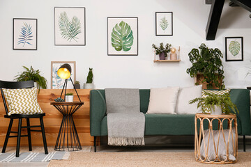 Stylish living room interior with comfortable sofa and green plants