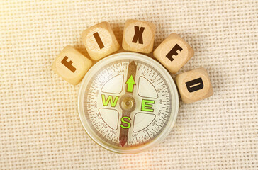 On the table is a compass and cubes with the inscription - FIXED