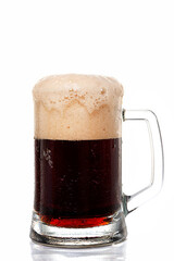 Dark beer with thick head of foam in glass beer mug on white background