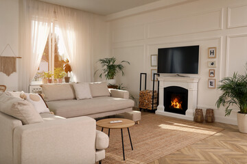 Stylish living room with comfortable sofas, modern TV and fireplace. Interior design
