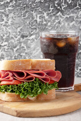 Focus on delicious sandwich with mortadella, lettuce, cheese and tomato.