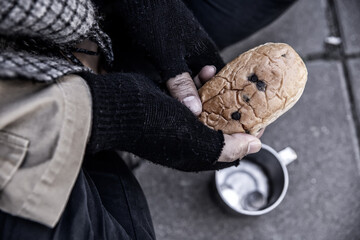 Bread in dirty hands of a homeless beggar.