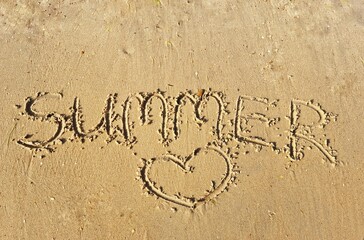 inscription on the beach. the word summer is written on the sandy seashore. travel tourism concept