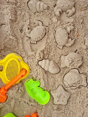 toys on the beach. Plastic shovel and sea animals sculpt toys in the sand. Favorite toys for...