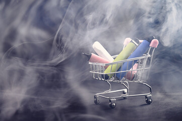 Disposable vapes in a shopping cart on a black background. Modern electronic cigarettes.