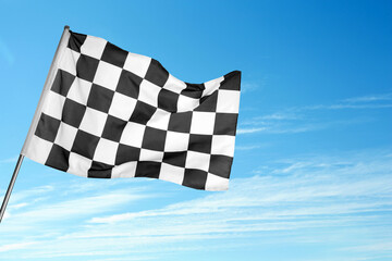 Checkered racing finish flag against blue sky