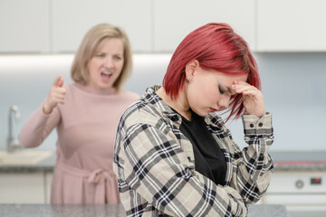 Family conflict. Mother screams at afraid teen daughter