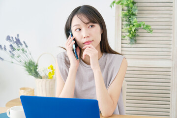 女性　電話する　リビング