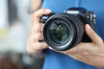 Professional woman photographer hold modern model of camera