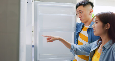 Fototapeta na wymiar couple looking at empty fridge