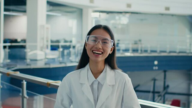 Asian Lady Wearing Protective Glasses And Lab Coat Laughing Indoor