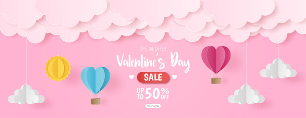 Paper cut of Valentine's Day sale background with pink and blue heart hot air balloons, sun and cloud on pink background, banner template