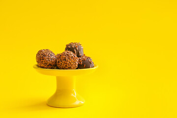Stand with tasty flax seed candies on color background