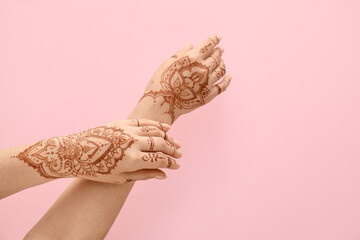 Beautiful female hands with henna tattoo  on pink background
