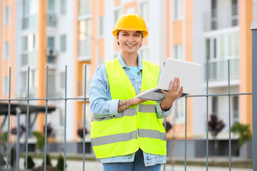 Female construction worker using laptop outdoors