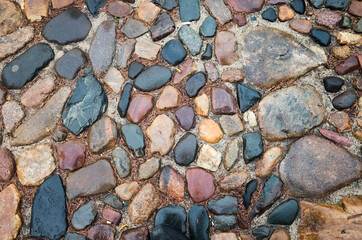 Textured beautiful natural abstract surface for wallpapers and backgrounds. Paving stones with round stones and earth between them
