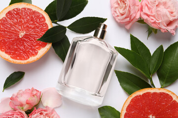 Composition with bottle of perfume and fresh citrus fruit on white background, top view