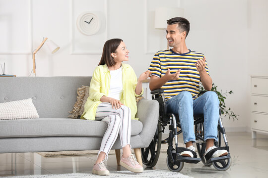 Young man in wheelchair and his wife at home