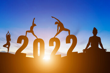 Happy New Year Numbers 2022, Silhouette woman practicing yoga early morning sunrise over the horizon background, Health and Happy new year concept.