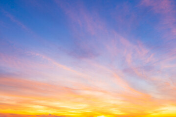 Twilight blue bright and orange yellow dramatic sunset sky in countryside or beach colorful cloudscape texture with white clouds air background.