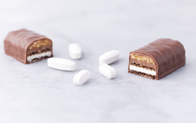 Energy bar and sports supplements on bright stone background. Soft focus. Close up. Copy space.