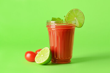 Glass of bloody mary with celery, lime and tomatoes on color background