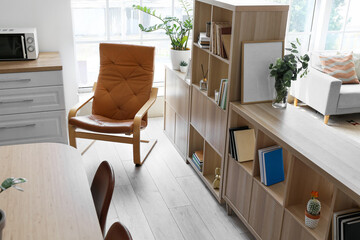 Comfy armchair and bookshelf in stylish room