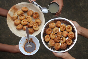 Plates of homemade panipuri or golgappa filled with potatoes along with sauce and mint water ready...