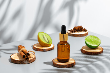 Fruit essential oil in glass bottle on gray background
