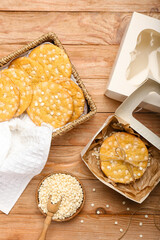 Basket and paper box with tasty chocolate cookies on wooden background